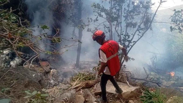 হেলিকপ্টার বিধ্বস্তের পর ঘটনাস্থলে কাজ করছেন এক উদ্ধারকর্মী। ছবি-সংগৃহীত